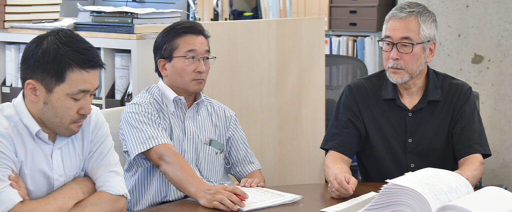 設計に関する資料を確認しながら打ち合わせを行うスタッフ